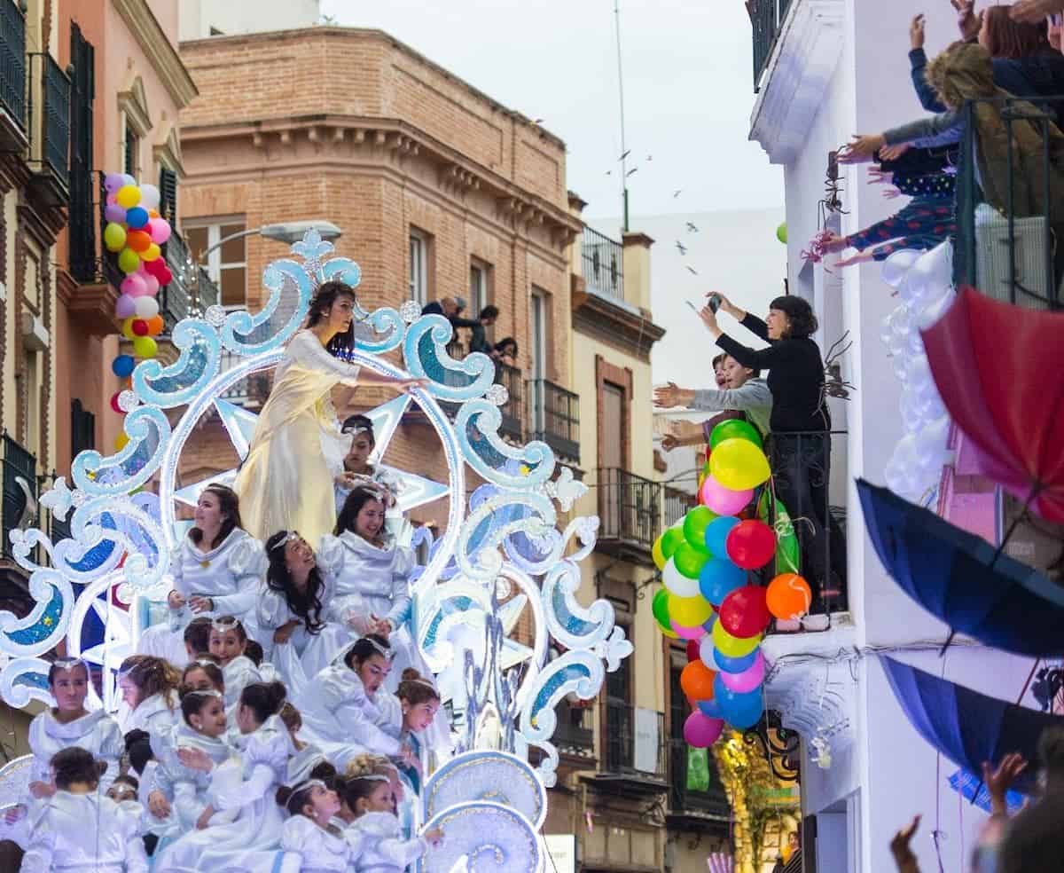 Specially-designed cart/float for the occasion of 3 kings day parade reyes magos cabalgata, with girls dressed as ferries and balloons on top of it. 